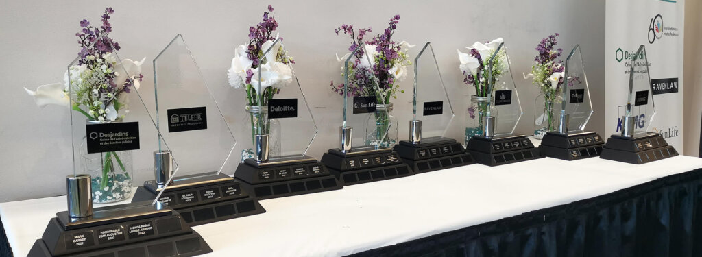 Awards of excellence displayed on a table with flowers