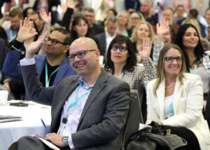 Photo people raising their hand at a conference